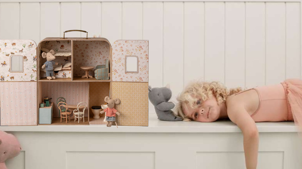Maileg suitcase dolls house on a shelf with a girl lying down and some sof toys