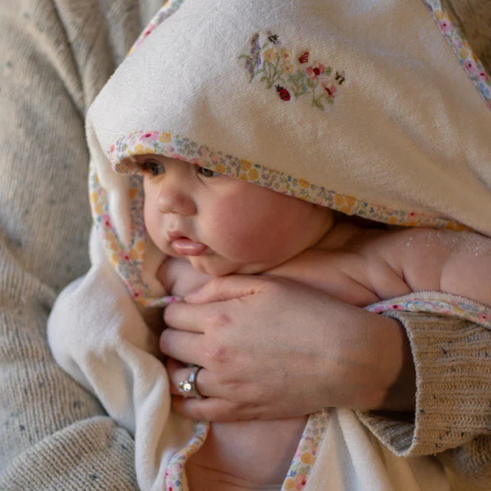 baby in a hooded bathrobe by avery row