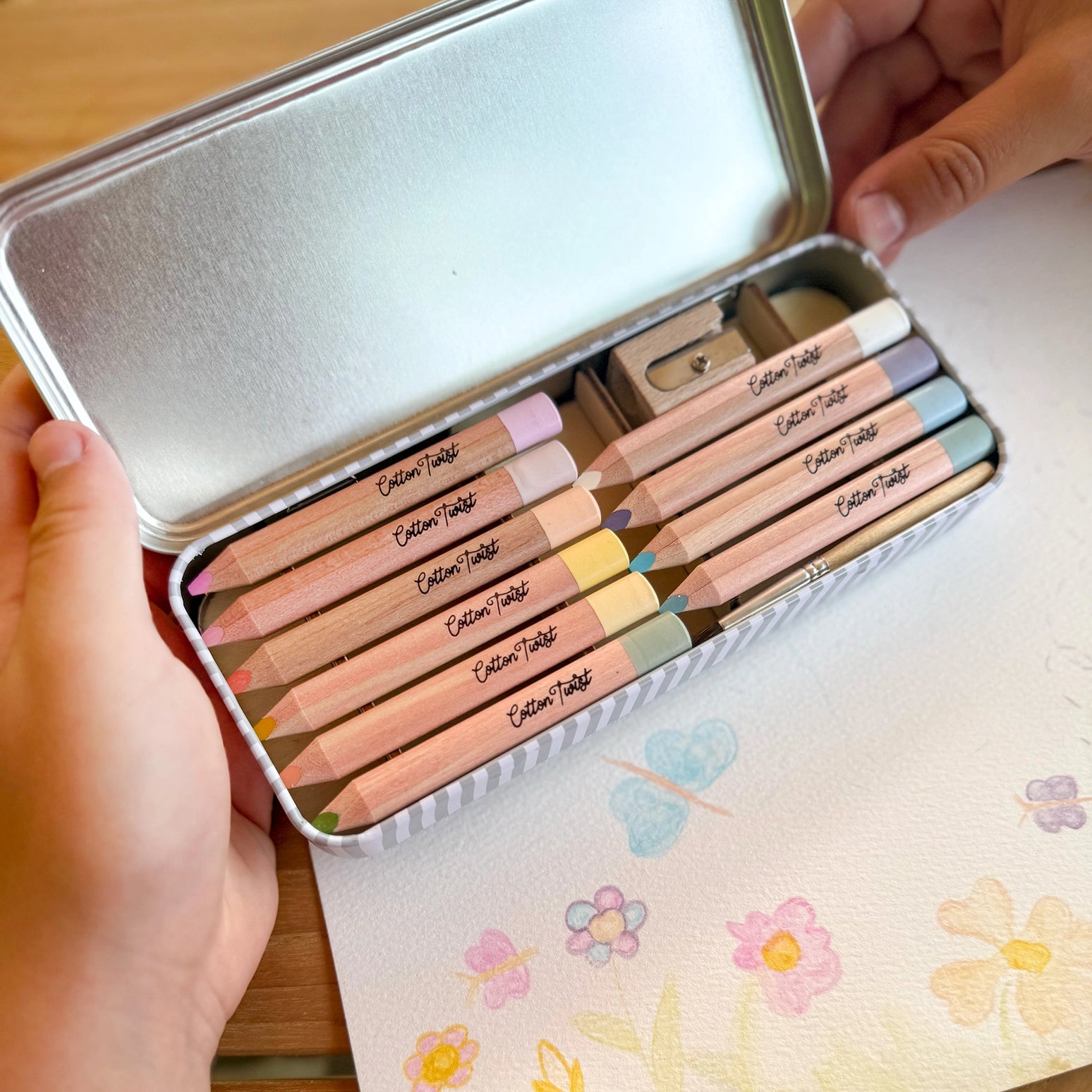 Set of colored pencils in a tin with floral notebook