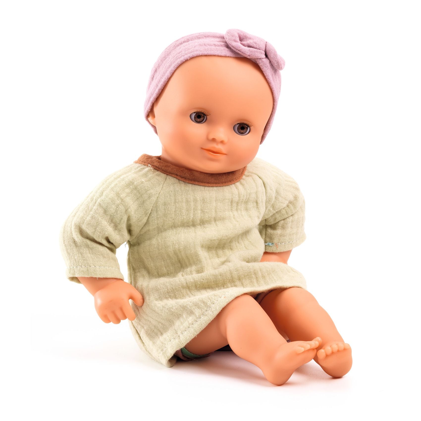 Baby doll wearing a light green dress and pink headband on a white background
