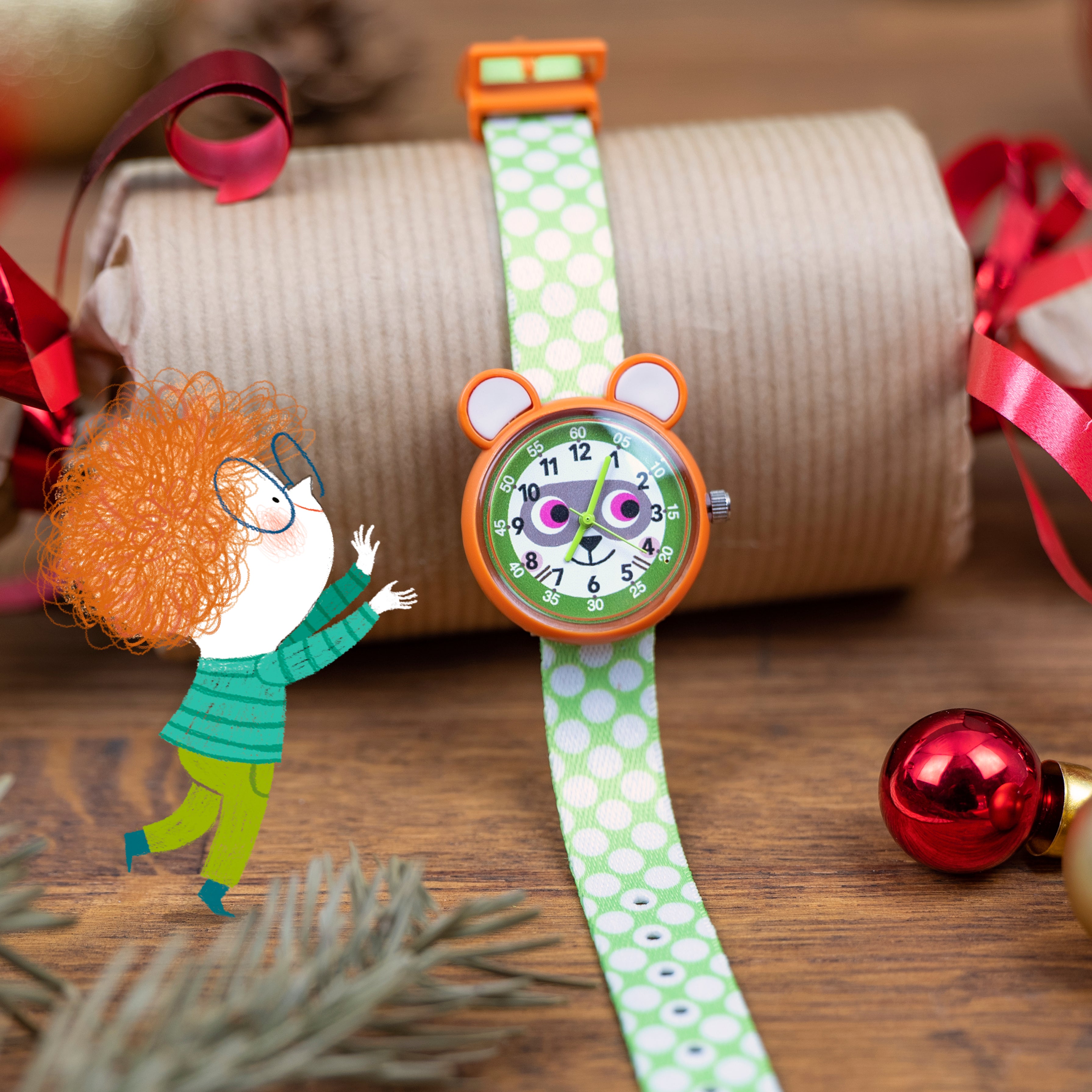 Children's watch with a cartoon character face, green strap, and orange accents on a wooden surface with decorative elements.