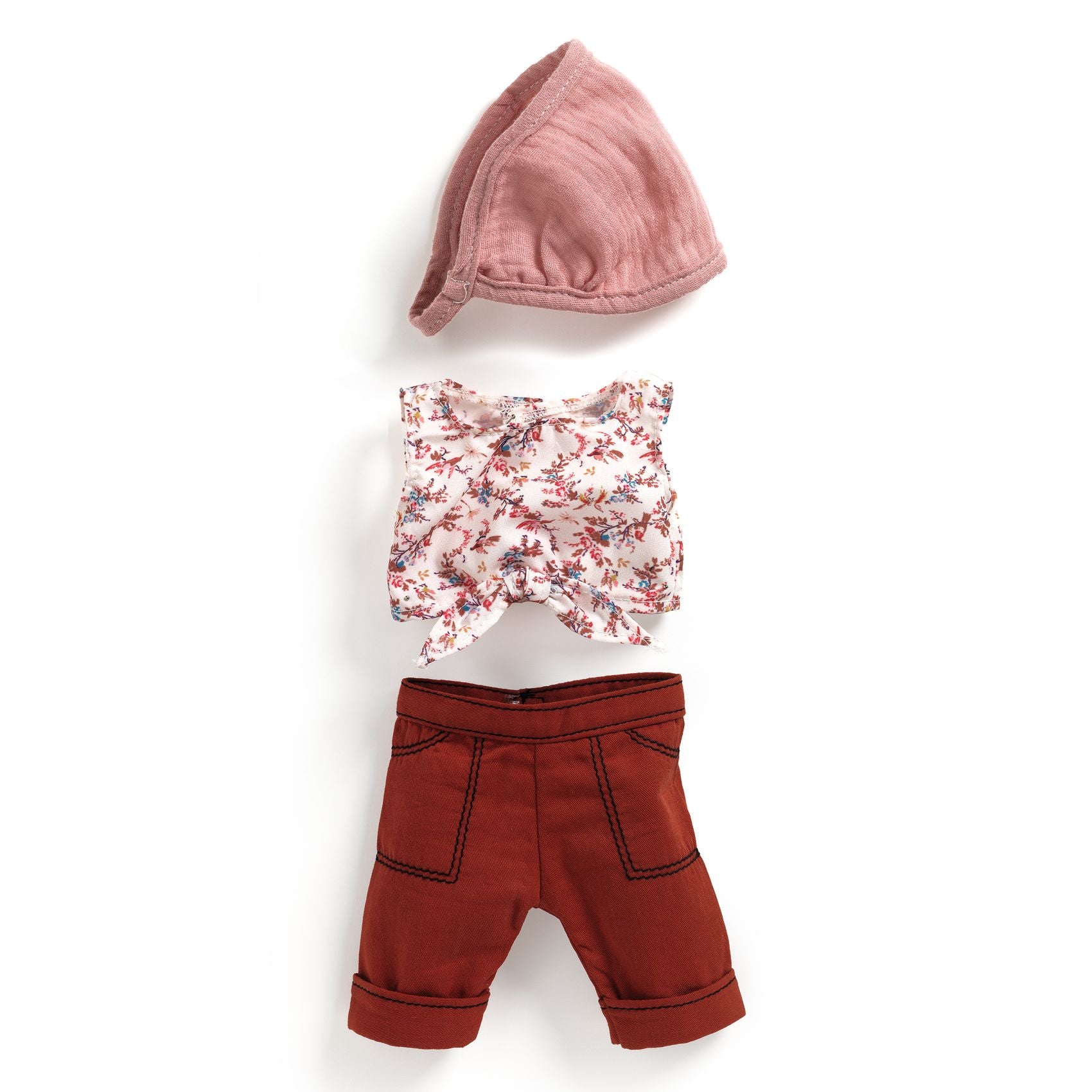 Set of children's clothing including a pink hat, floral top, and red shorts on a white background