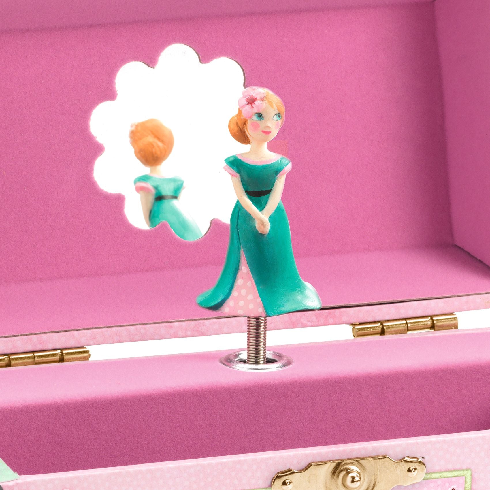 Figurine of a woman in a green dress inside a pink jewelry box with a gold clasp.