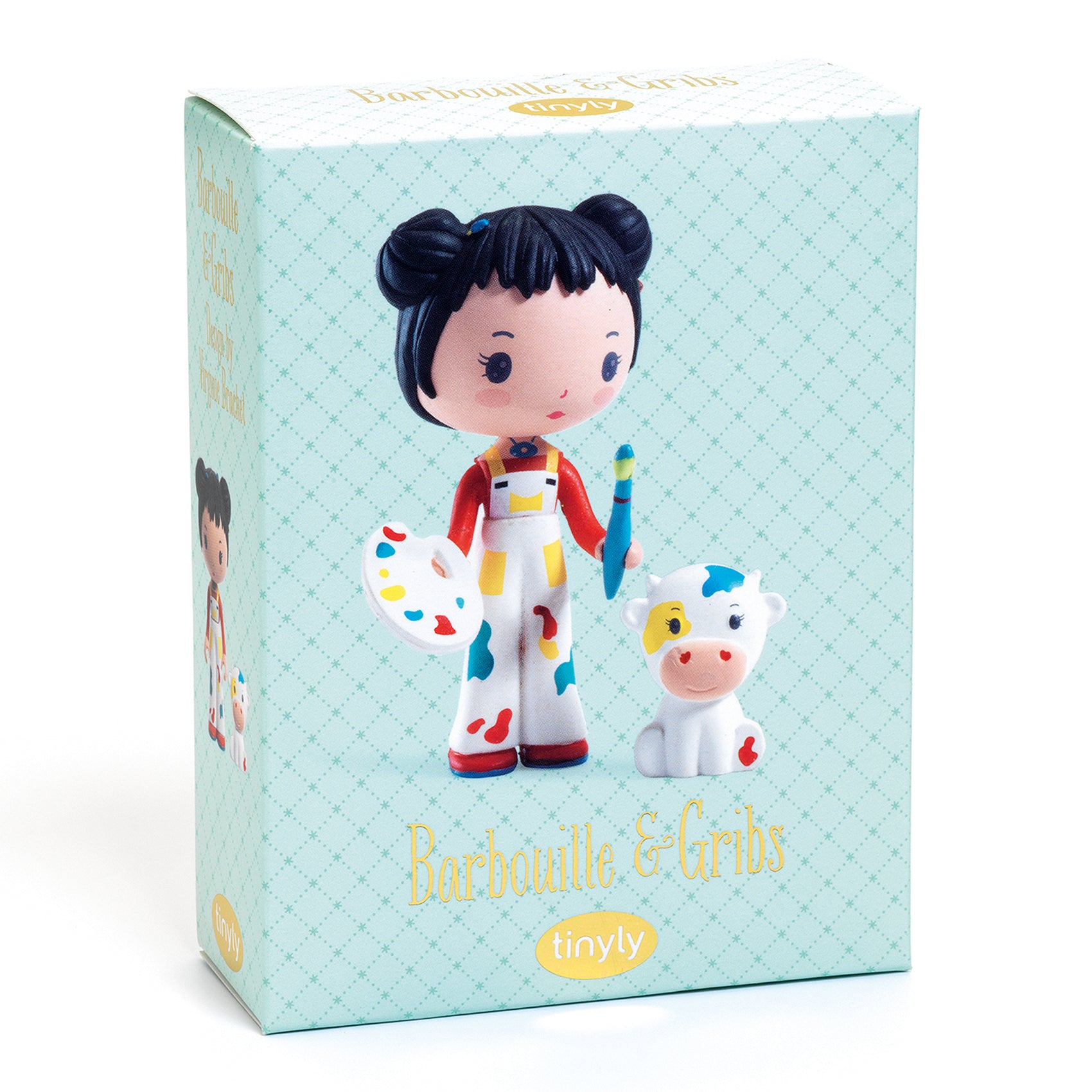 Box packaging of an artist figurine with a cow toy on a light blue background