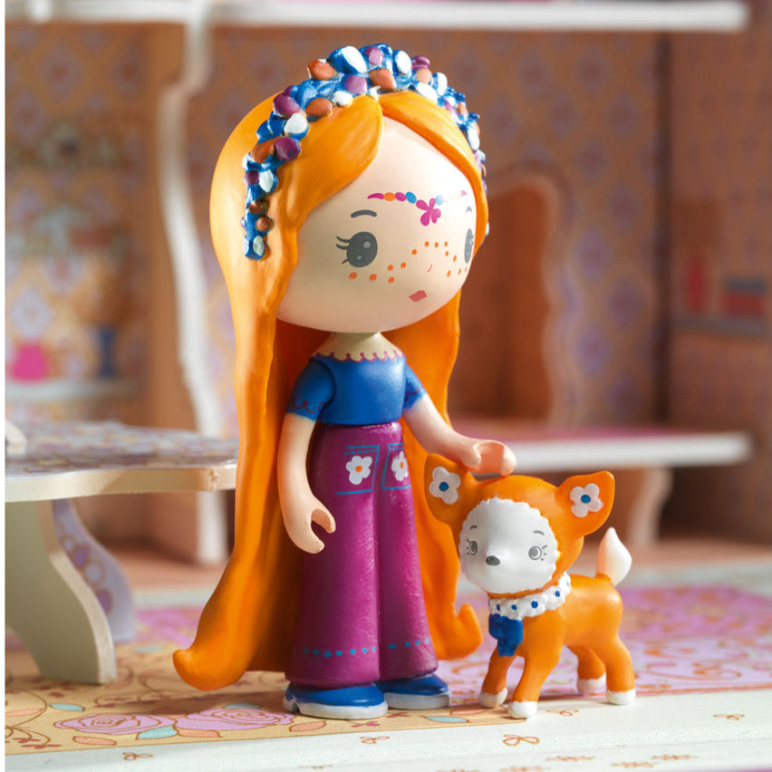Toy figure of a girl with long hair and a small dog in a colorful room.