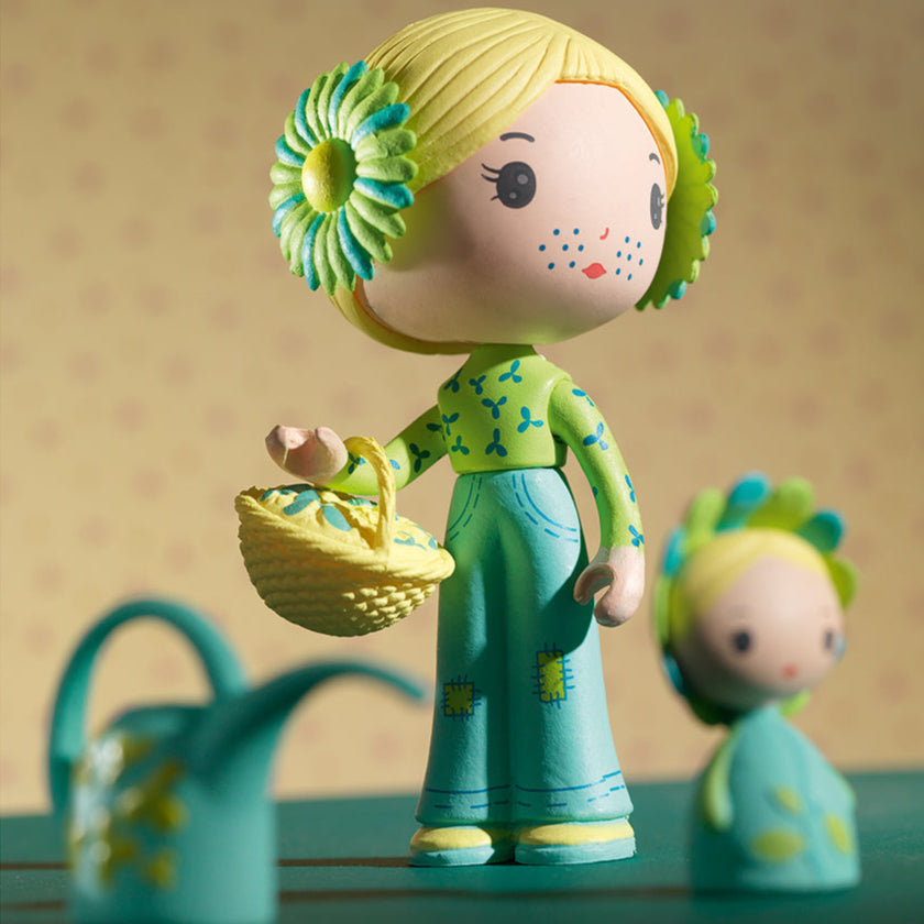 Colorful toy figure with floral hair accessories on a plain background