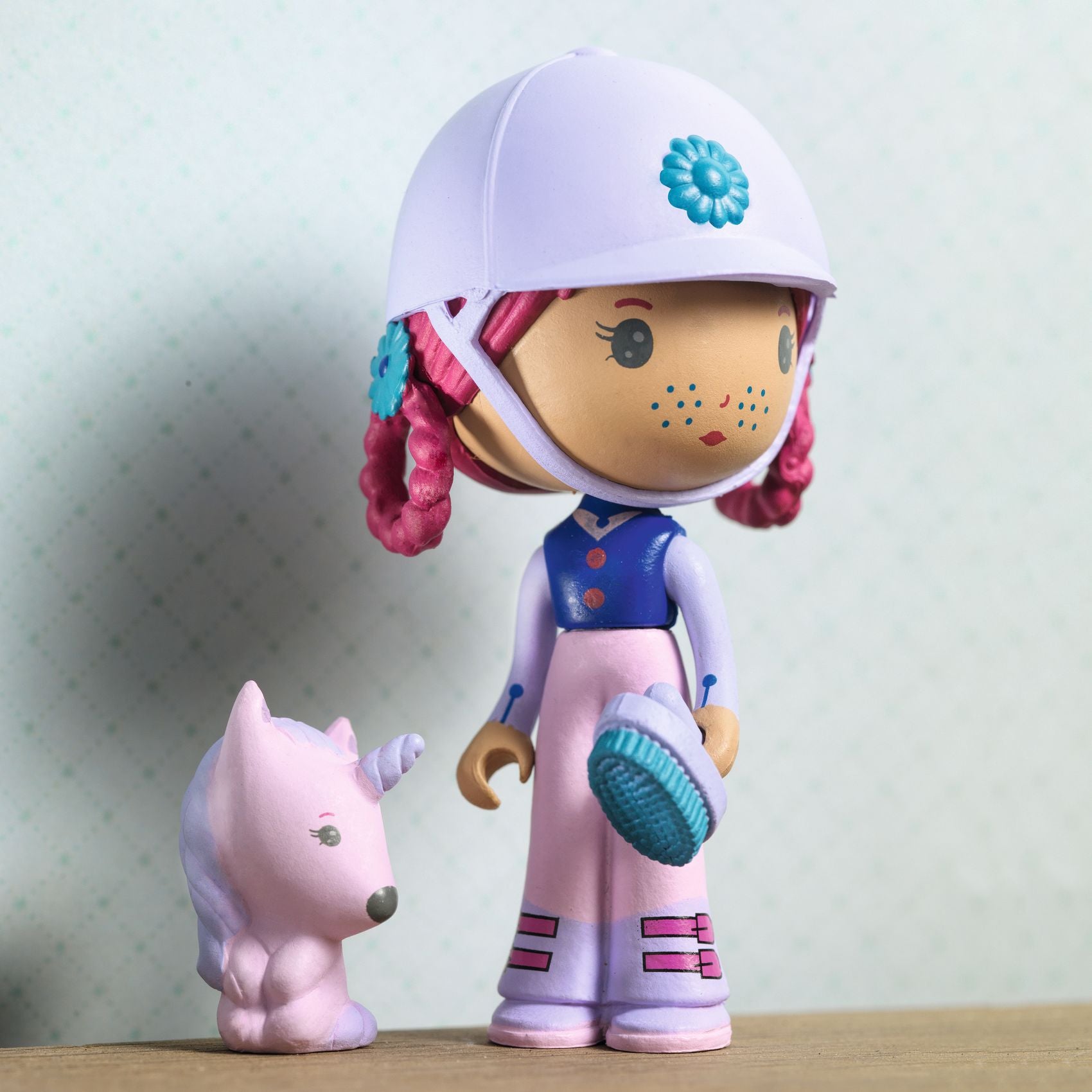 Colorful toy figure with helmet and pink unicorn on a light background