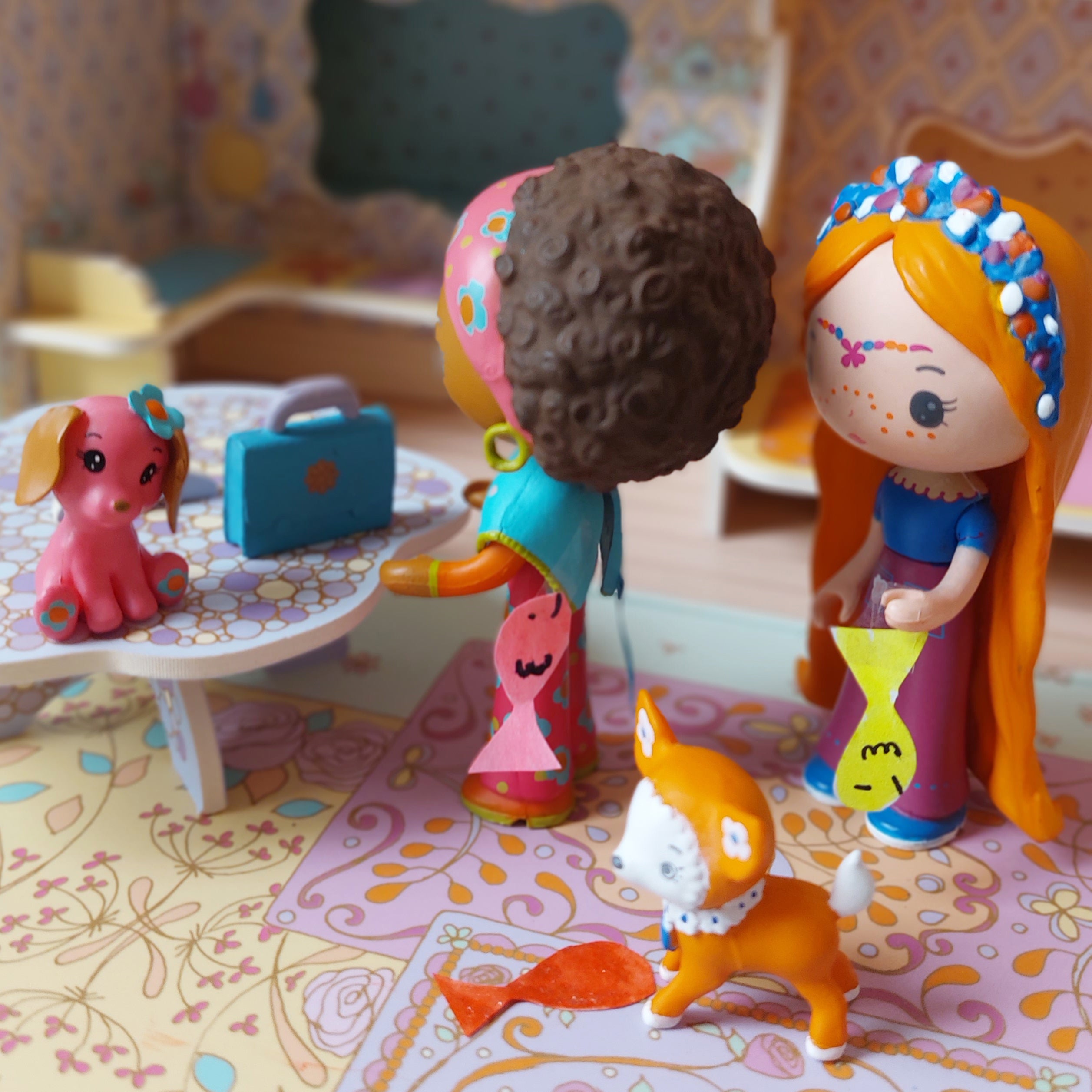 Toy figures of children and animals in a colorful room setting