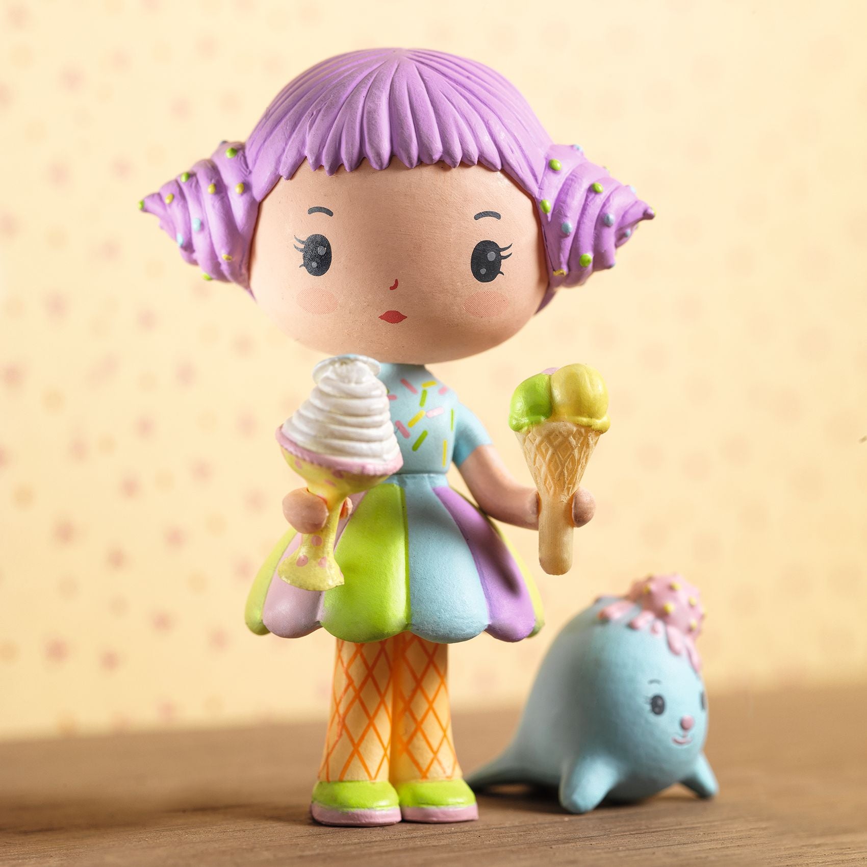 Colorful figurine with purple hair and ice cream-themed outfit on a wooden surface