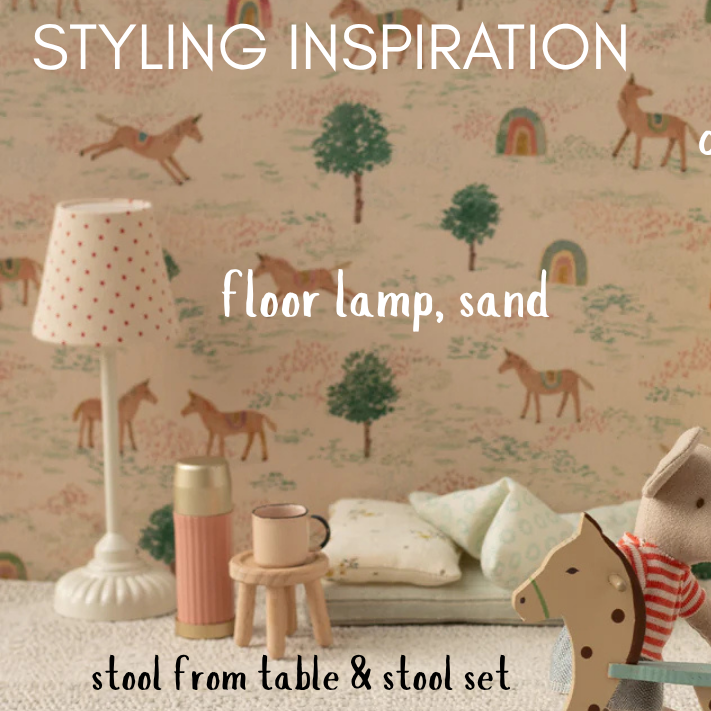 dolls house room with toys, lamp, and wardrobe against a patterned wall.