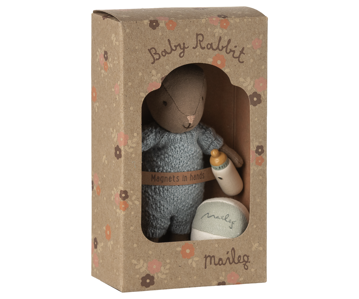 Stuffed toy rabbit in a cardboard box with 'Baby Rabbit' text and Maileg branding.
