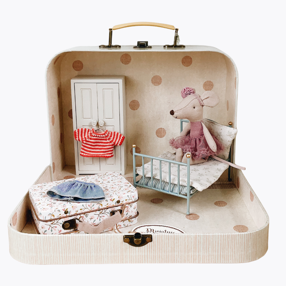 Miniature dollhouse set inside a suitcase with a mouse character, clothes, and furniture.