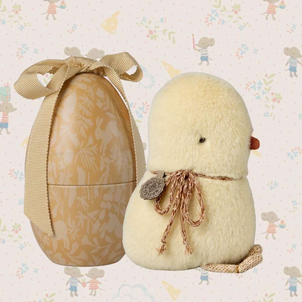 Decorative egg with a chick on a patterned background
