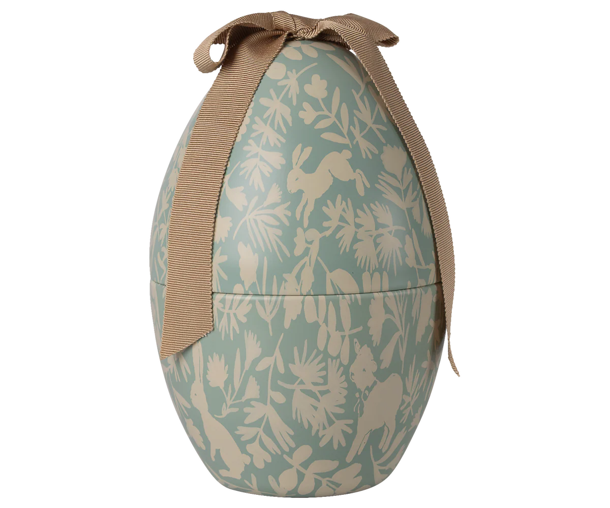 Decorative Easter egg with rabbit and leaf pattern and brown ribbon on a white background