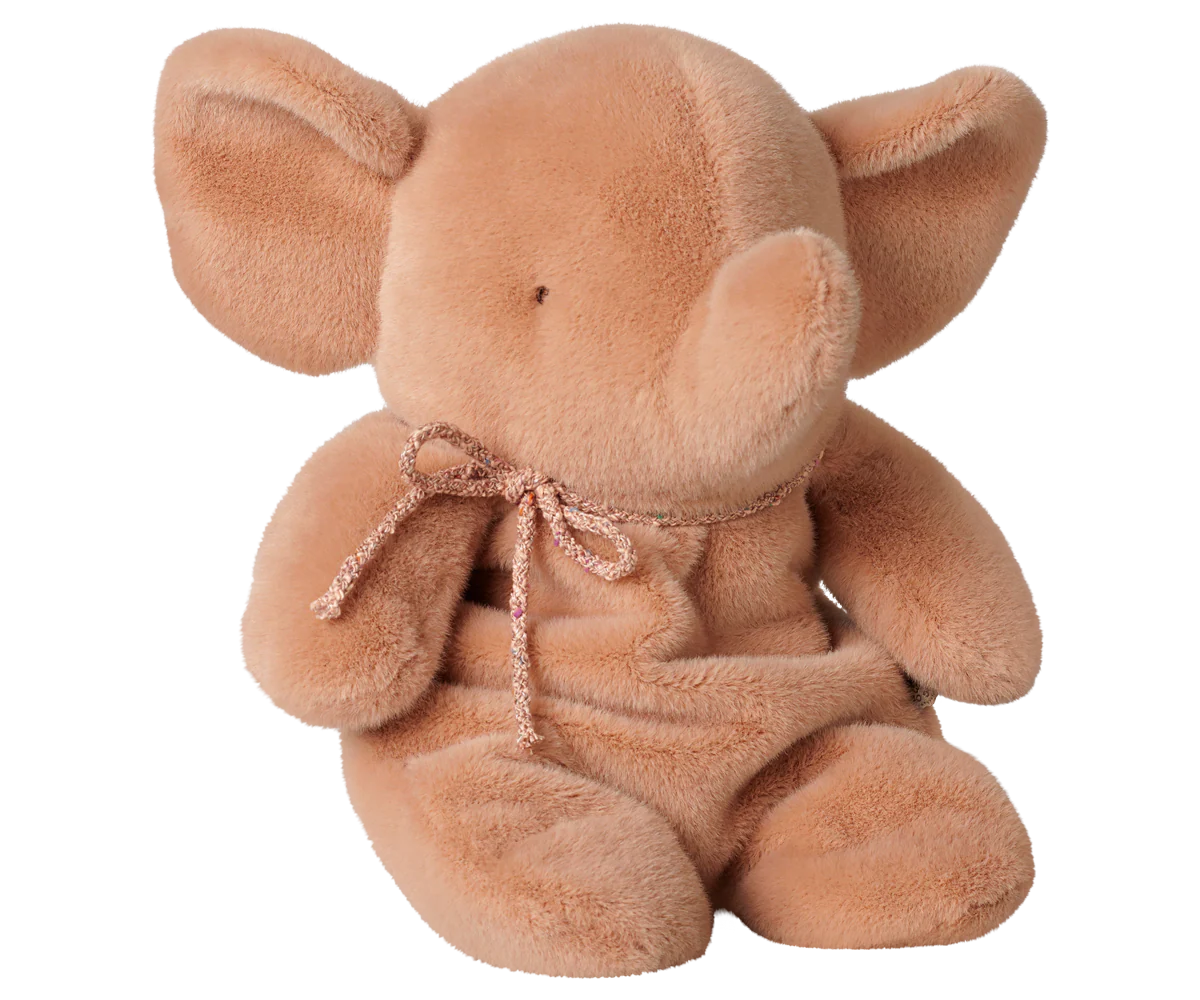 A soft plush elephant toy in a warm tan-brown color, sitting upright against a plain white background. It has large floppy ears, a small stitched face, and a matching fabric bow tied around its neck.