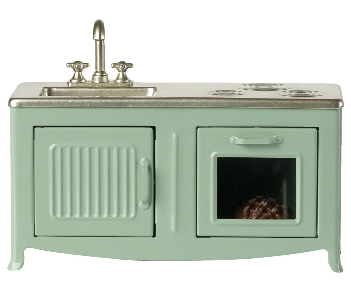 Mint green toy kitchen with sink and stove on a white background