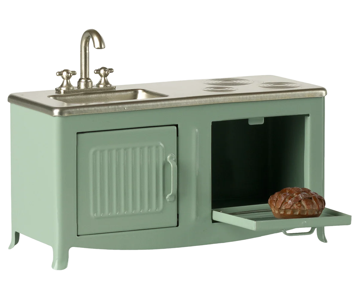 Green toy kitchen set with sink and stove on a white background