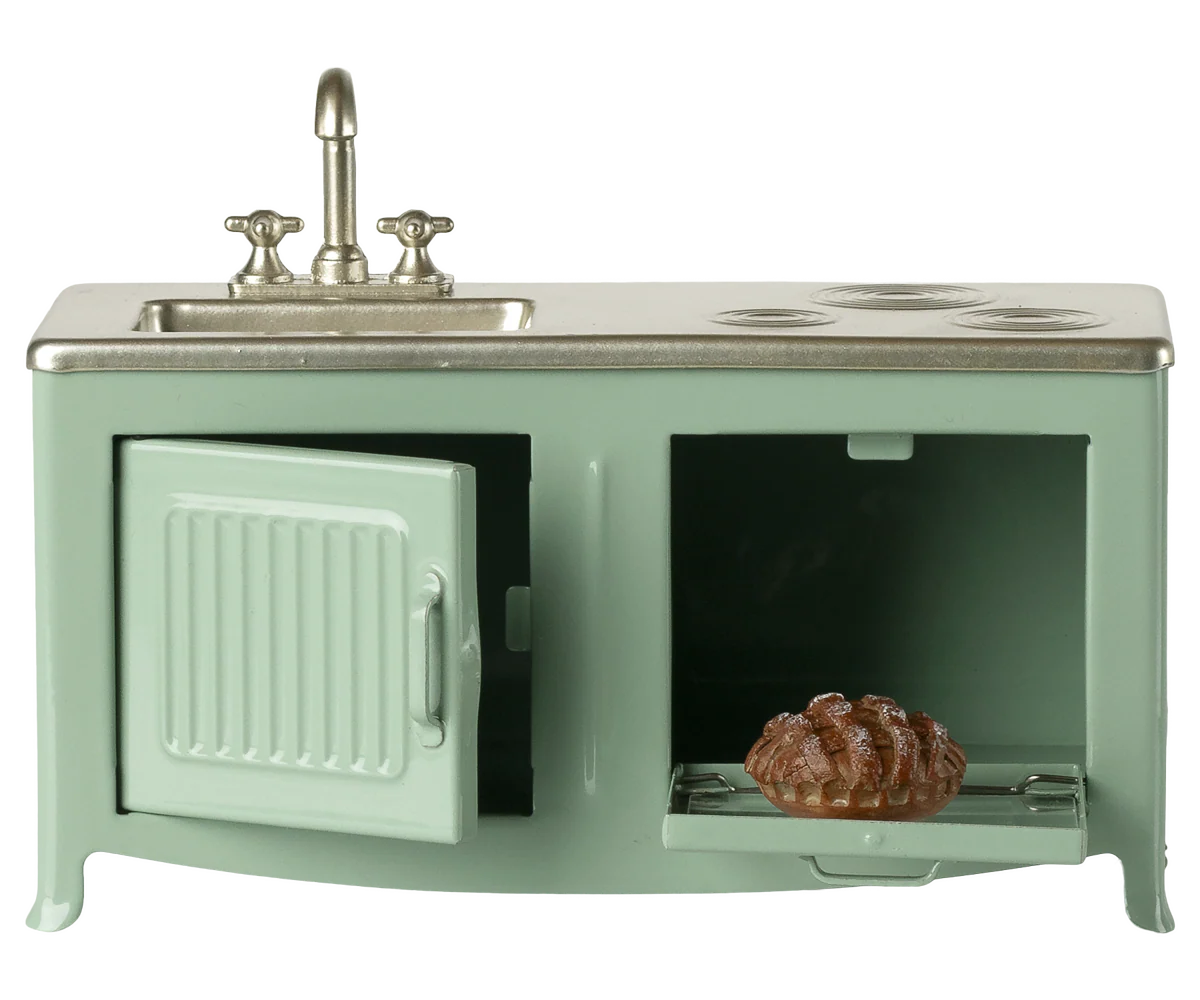 Miniature green kitchen set with sink and stove on a white background