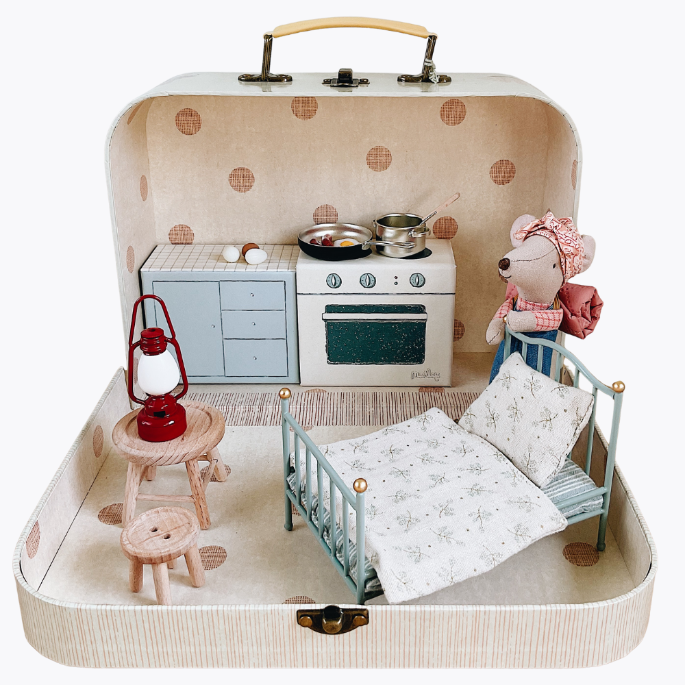 Toy playset inside a suitcase with kitchen, bed, and mouse figure.