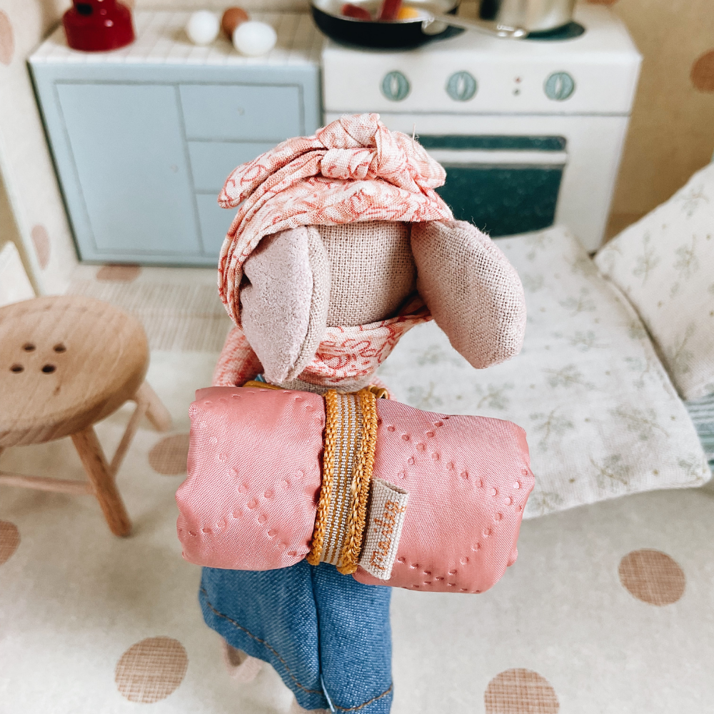 Stuffed toy maileg mouse with pink outfit in a cozy room setting