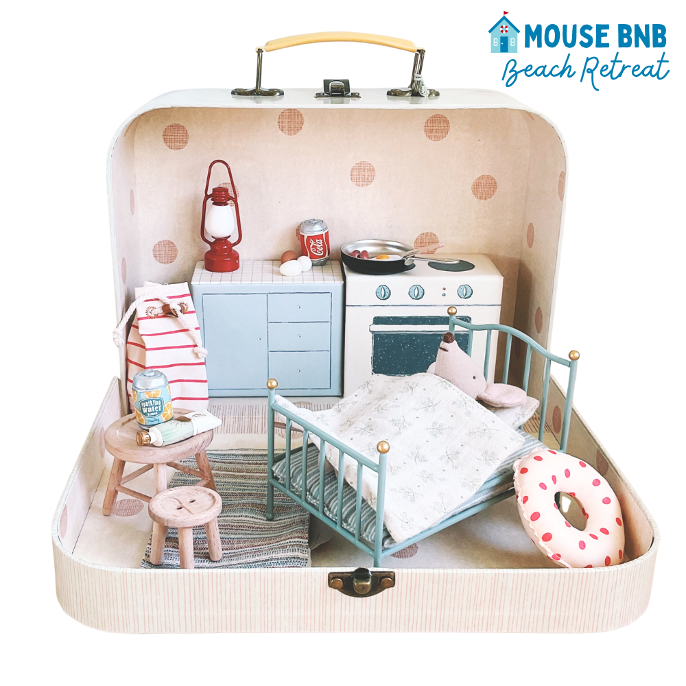 Miniature dollhouse setup inside a suitcase with 'Mouse BNB Beach Retreat' branding.