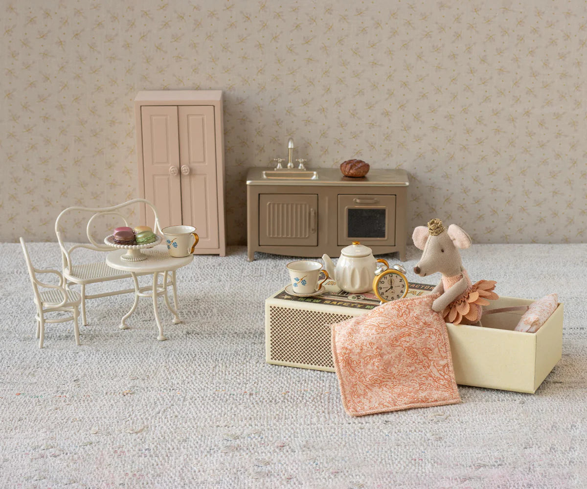 Miniature dollhouse furniture set with a mouse figure and tea set on a neutral background