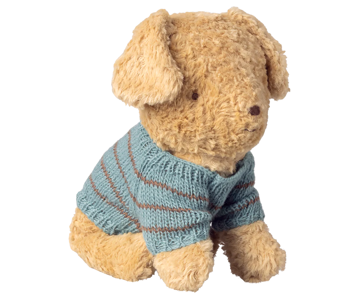Stuffed dog wearing a blue striped sweater on a white background