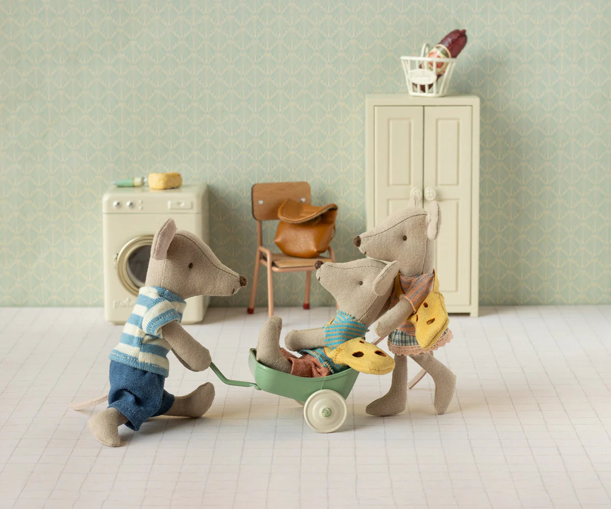 Maileg toy mice in a miniature room with a washing machine and chair.