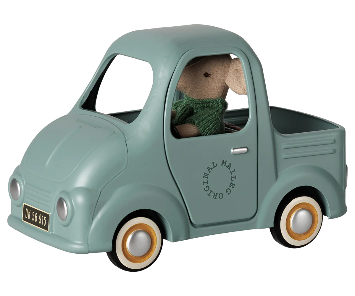 A mint green toy pickup truck with a plush mouse driver wearing a green knit sweater. The toy truck features vintage-style wheels with tan rims, a black license plate, and 'ORIGINAL MASHUP' branding printed on the side door.