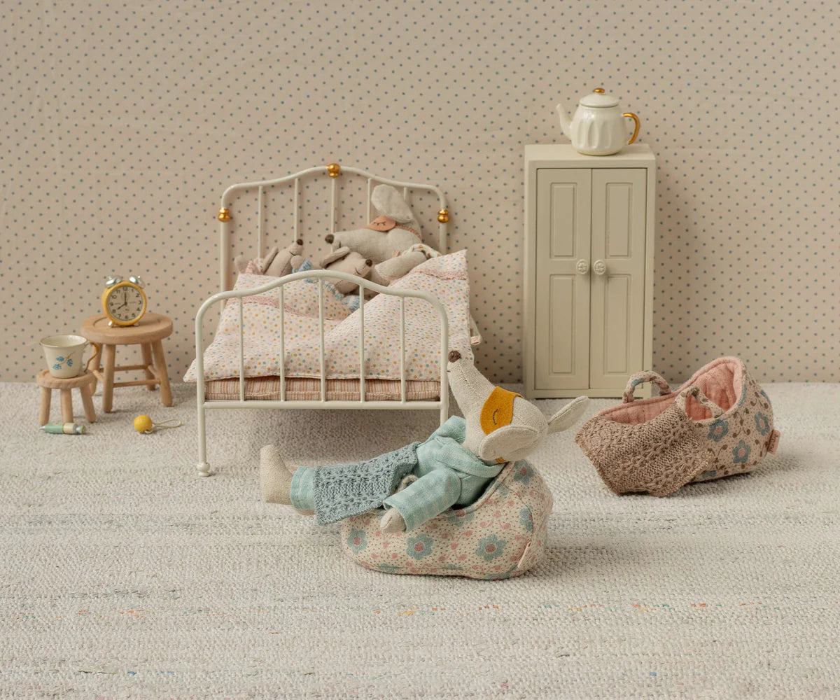 Miniature Maileg bedroom scene with a bed, mouse toys, and furniture.
