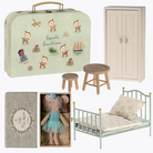 Collection of Maileg dolls house furniture  including a suitcase, bed, and dolls on a white background.