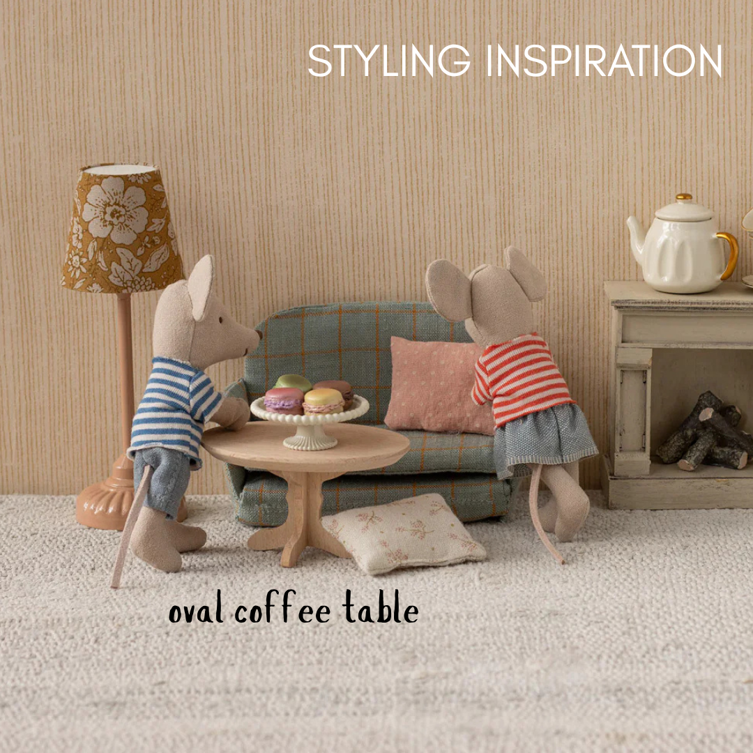 Miniature mouse figures in a living room setting with furniture and decor.