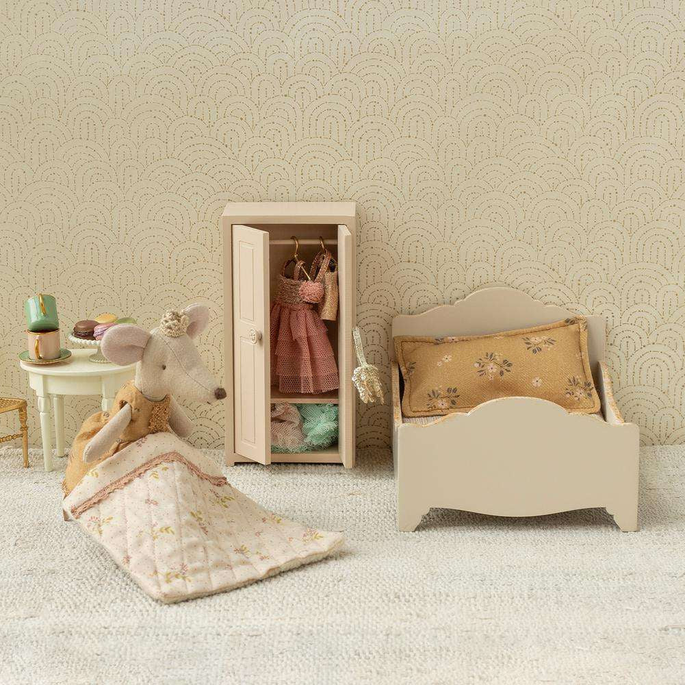 Maileg Miniature bedroom set with bed, chair, a princess mouse and wardrobe against a patterned wall.