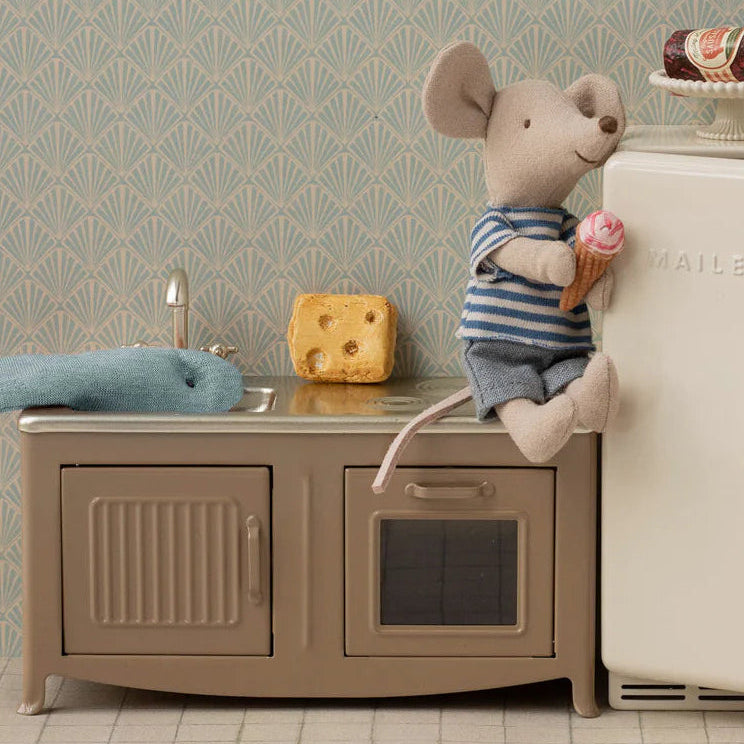 Two toy mice in a kitchen setting with a refrigerator and sink.