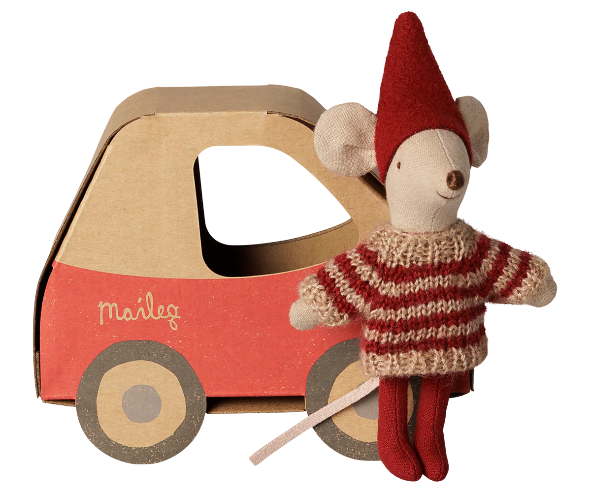 A Maileg mouse doll wearing a red and beige striped knit sweater and red hat, posed next to a red and brown cardboard toy car with the Maileg logo on the side, on a white background.
