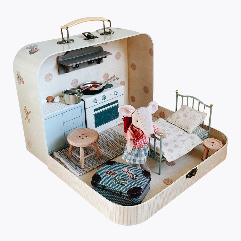 Toy suitcase with a kitchen, bedroom, and mouse character inside on a white background