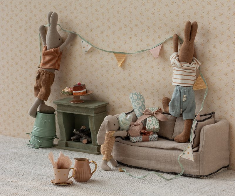 Maileg rabbits in a living room hanging up bunting