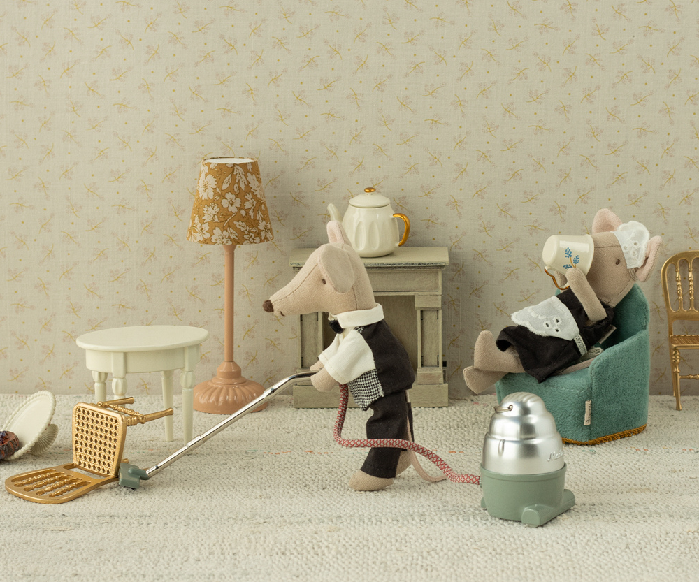 MAileg mice watier and maid in a living room with a vacuum cleaner
