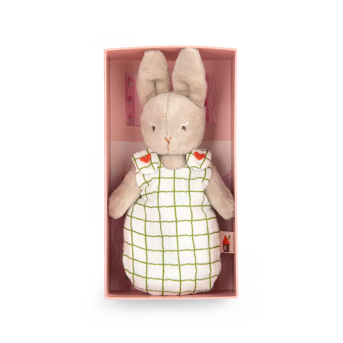 Stuffed rabbit toy in a checkered dress with red hearts in a pink box on a white background