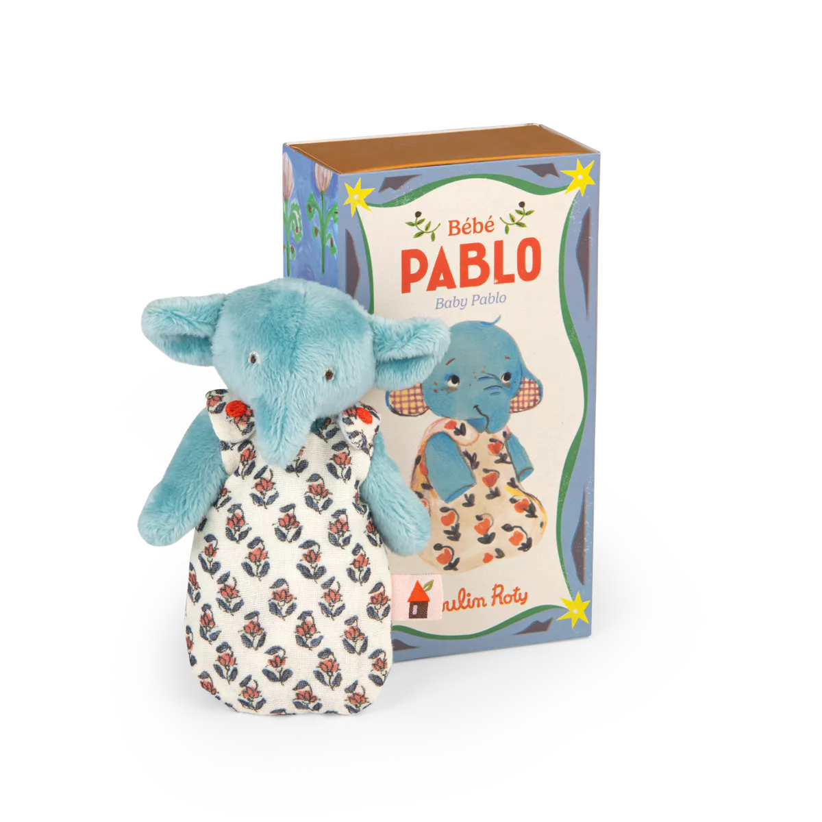 Blue elephant plush toy with floral patterned outfit next to its packaging on a white background