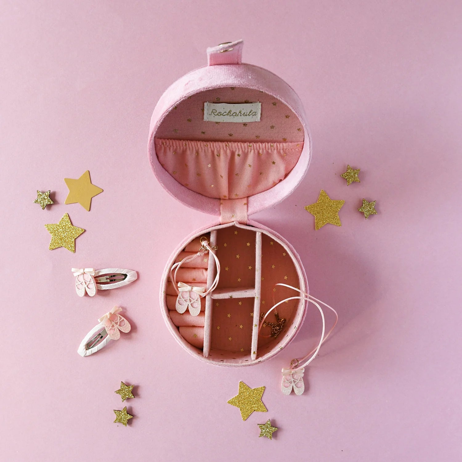 Pink jewelry case with accessories on a pink background