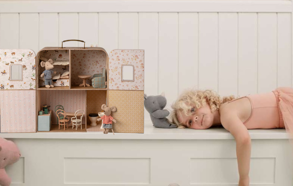 Maileg suitcase dolls house on a shelf with a girl lying down and some sof toys