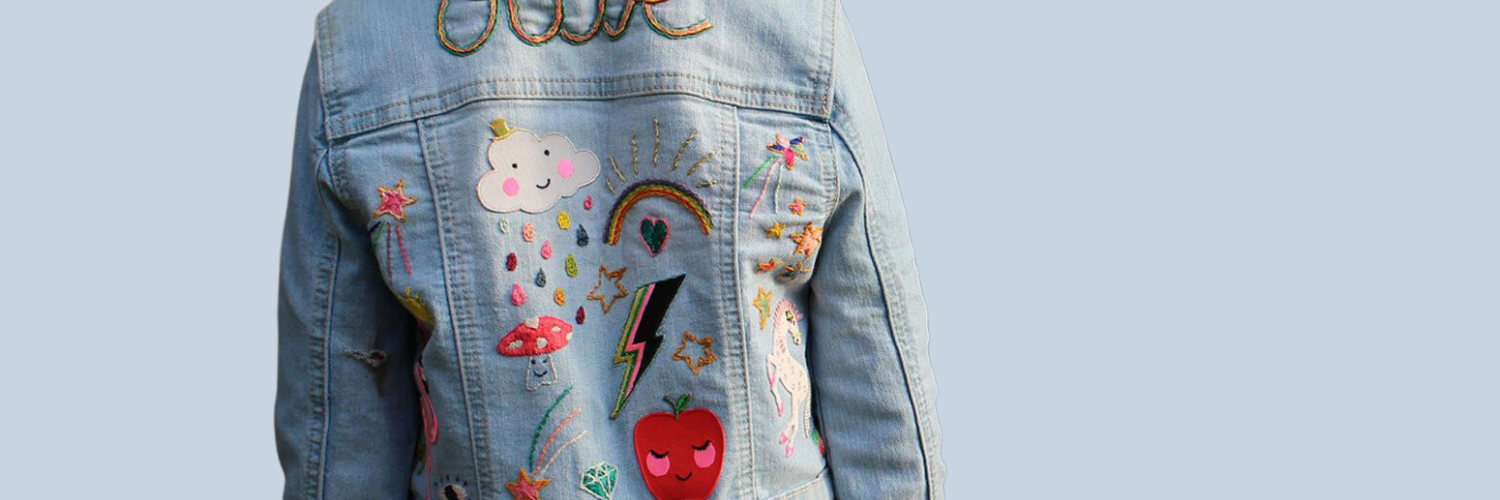 A denim jacket covered with iron on patches by Petra Boase.