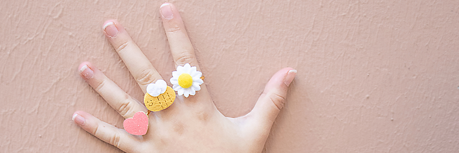 A girl's hand wearing a selection of Rockahula Kids rings