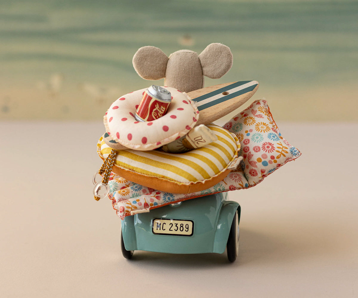 Maileg Small toy car with a stack of colorful items on a blurred background