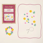 Flower bracelet-making kit with packaging, string, and flower-shaped beads on a beige background