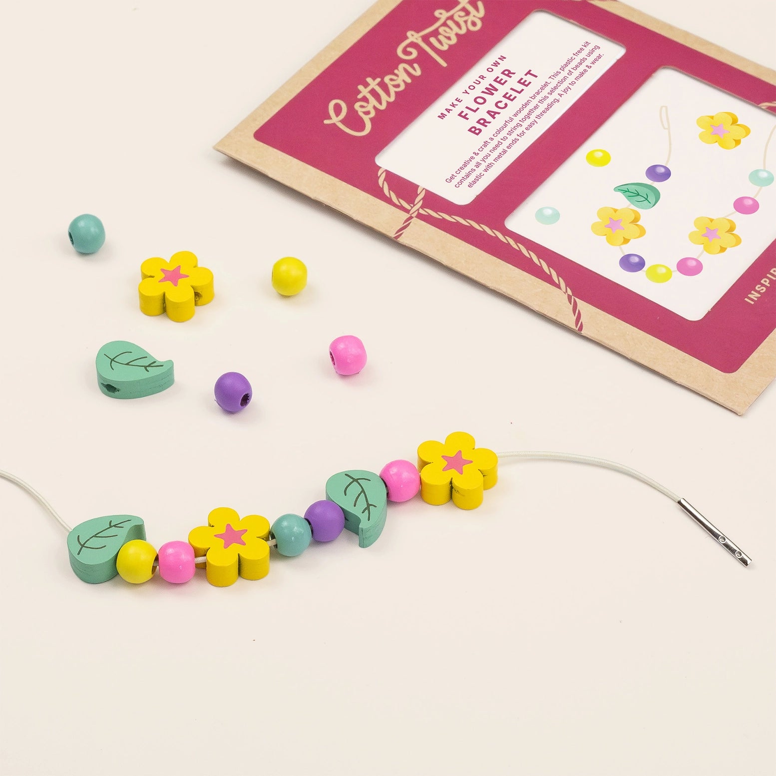 Colorful beaded flower bracelet with a craft kit on a light background