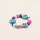 Colorful bracelet with shell-shaped beads on a beige background