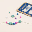 Colorful beaded bracelet with a cardboard packaging on a light background
