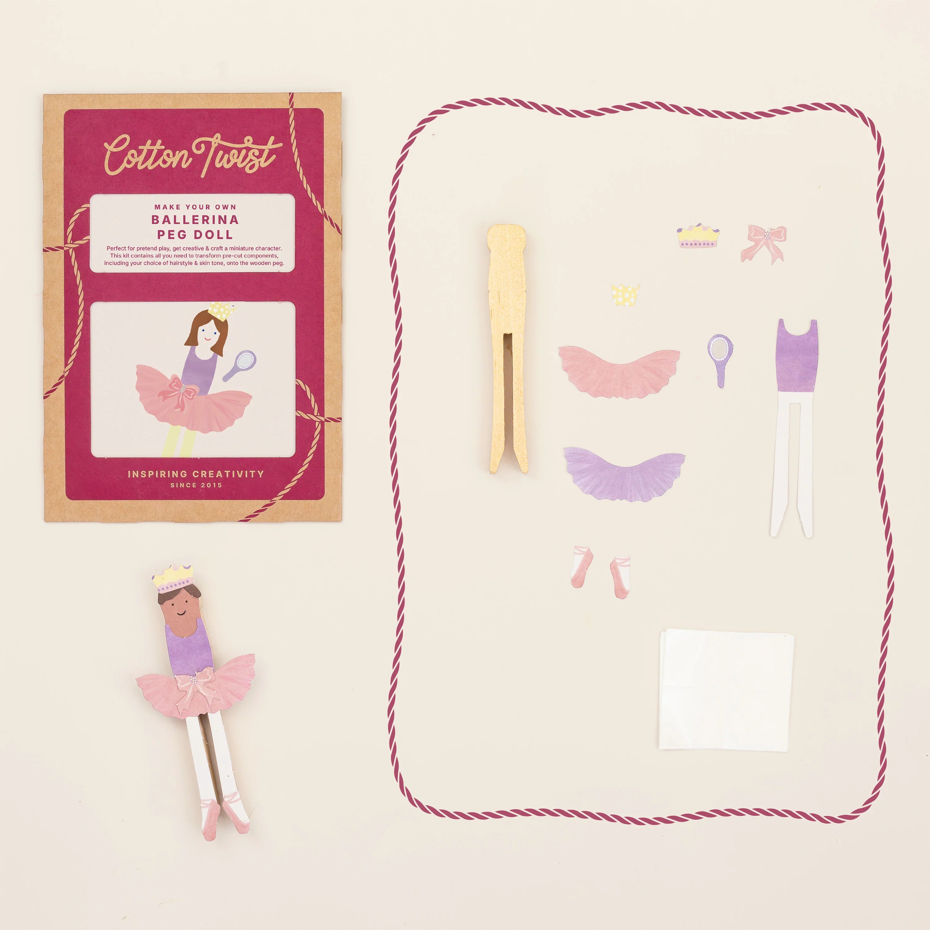 Ballerina peg doll set with packaging and accessories on a light beige background